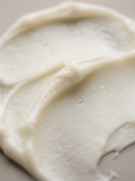 A close-up shot of a Formed Everyday Balm swirled on a neutral beige background.